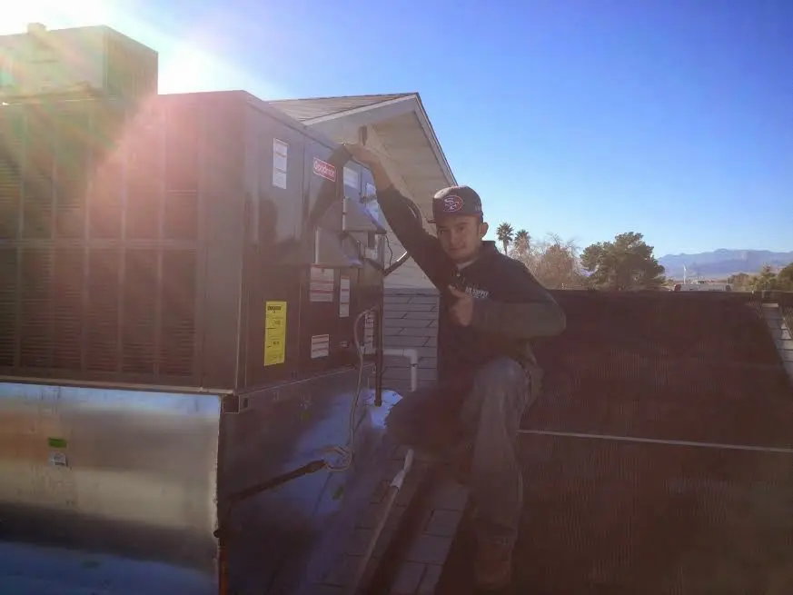 HVAC technician performing HVAC Inspection on a rooftop unit in Forest City